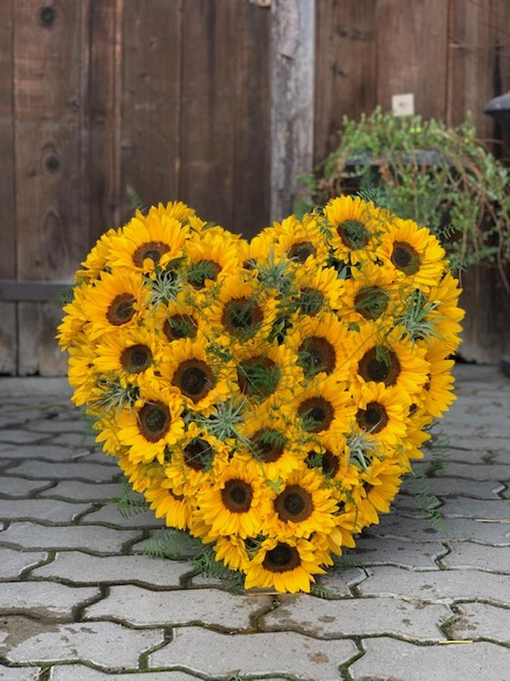 Ein Blumenherz mit Sonnenblumen (saisonal) wunderschön natürlich verarbeitet zur Beerdigung von Blumen Aurora in Urdorf und Umgebung